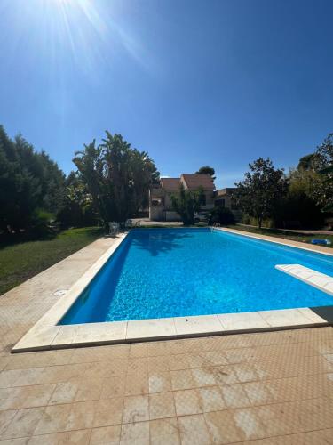 - une piscine d'eau bleue en face d'une maison dans l'établissement PROJEKT X, à Villasmundo