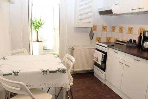 - une cuisine avec une table, une table et des chaises dans l'établissement Ferienwohnung Am Wald, à Michendorf