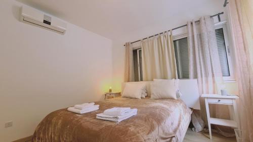 Aglantzia的住宿－STAY Tranquil Terrace，一间卧室配有一张床,上面有两条毛巾