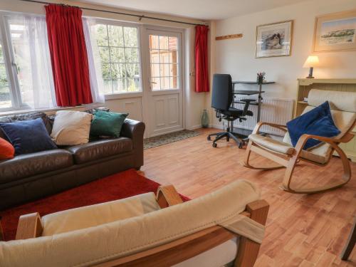 een woonkamer met een bank en stoelen en een bureau bij Little Barber in Reading