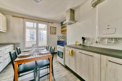 une cuisine avec une table et des chaises dans une pièce dans l'établissement La Dolce Vita¶ Belle vue ¶ Confort ¶Proche TRAM, à Grenoble
