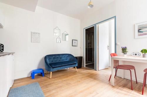 un salon avec une chaise bleue et une table dans l'établissement Charmant T1 Bis proche Gare et Centre Ville, à Lourdes