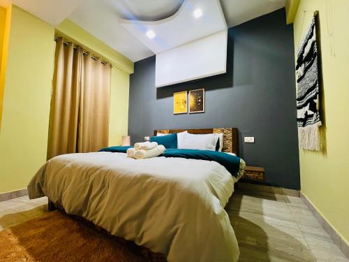 ein Schlafzimmer mit einem großen Bett mit blauen Wänden in der Unterkunft Luna & Sol 2BHK in Kasauli