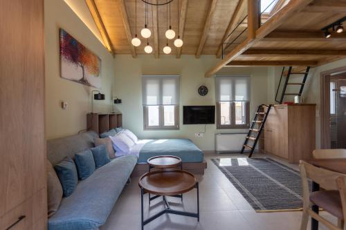 a living room with a blue couch and a table at Akti Vigla Apartments in Mytilini