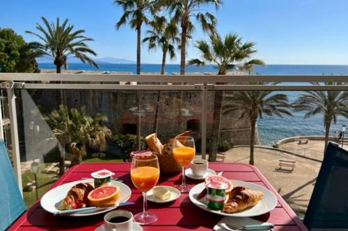 a table with two plates of food and glasses of orange juice at Antibes sea view near Ilette - Sleeps 4 - Parking in Antibes