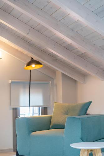 a living room with a blue couch and a lamp at Akti Vigla Apartments in Mytilini