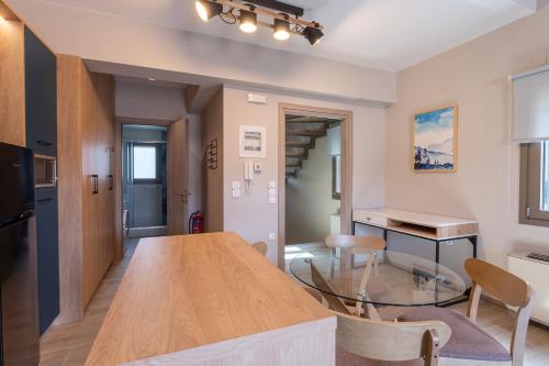 a kitchen and living room with a wooden table and a counter at Akti Vigla Apartments in Mytilini