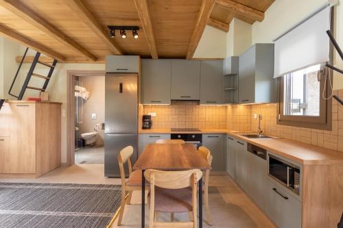 a kitchen with a wooden table and a wooden ceiling at Akti Vigla Apartments in Mytilini