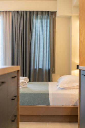 a bedroom with a bed and a window at Akti Vigla Apartments in Mytilini