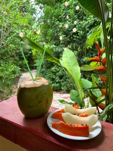 a plate of fruit and an apple on a table at Pousada Marina de Boipeba in Ilha de Boipeba