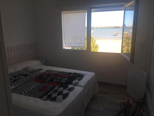 een slaapkamer met een bed en uitzicht op de oceaan bij Chalet sobre la playa , in El Rompido