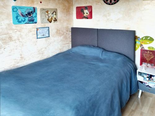 - une chambre avec un lit et une couverture bleue dans l'établissement Maison de 5 chambres avec jardin clos et wifi a Maurepas, à Maurepas