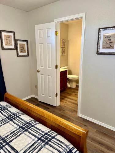 a bedroom with a bed and a bathroom with a toilet at Lakeside Motel, Cabins and RV in Kingston