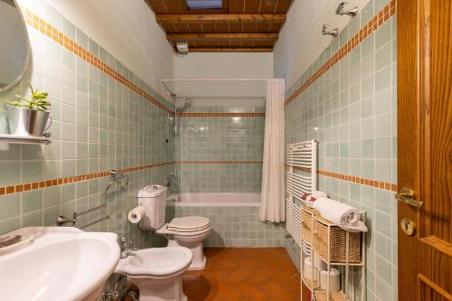 een badkamer met 2 toiletten, een wastafel en een bad bij Podere San Bartolo- Casa colonica 2 in Barberino di Val dʼElsa