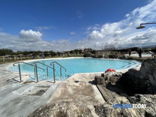 una grande piscina con acqua blu e rocce di La dimora di Sandy a Viterbo