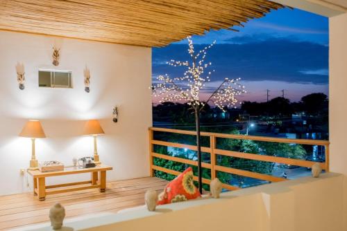 een kamer met een balkon met een tafel en een raam bij Hotel Mango Verde Bed & Breakfast in Piura
