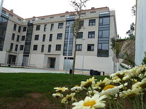 un edificio con un ramo de flores delante de él en Playa y piscina a tu alcance en boiro, en Boiro