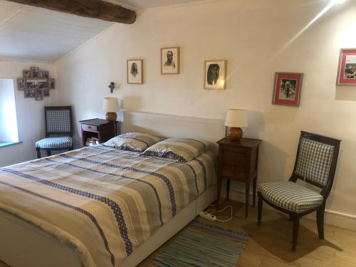 une chambre avec un lit et deux chaises dans l'établissement Appartement Duplex dans vieille maison Basque, à Urrugne
