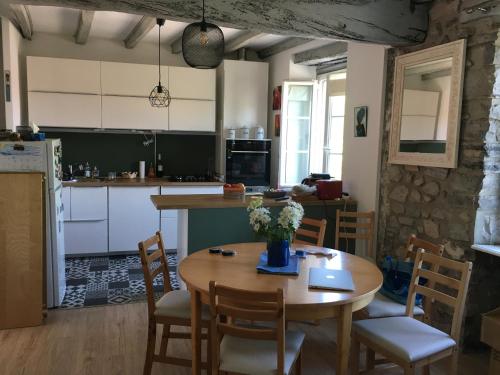 une cuisine avec une table en bois avec des chaises et une table sidx sidx sidx dans l'établissement Appartement Duplex dans vieille maison Basque, à Urrugne