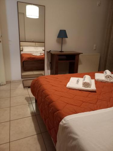 una camera d'albergo con due letti e uno specchio di A V G E R I N O S Athens ad Atene