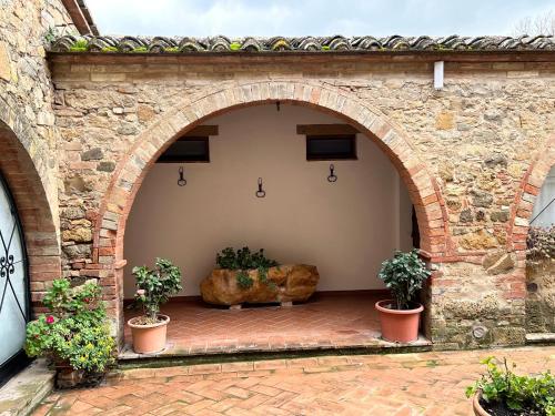 an archway in a stone building with two potted plants at Agriturismo Casalpiano in Pienza