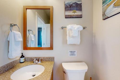 uma casa de banho com um lavatório, um WC e um espelho. em Searose Cottage em Yachats