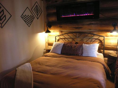 a bedroom with a bed with a television on the wall at Boulder Mountain Guest Ranch in Boulder Town