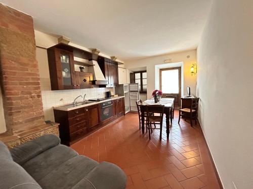 a kitchen and living room with a table and a couch at Agriturismo Casalpiano in Pienza
