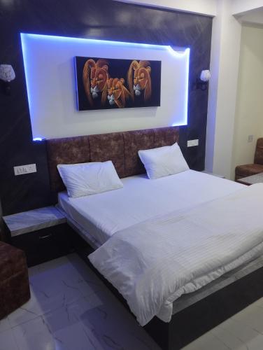 ein Schlafzimmer mit 2 Betten und einem Löwengemälde in der Unterkunft Hotel anand shree in Hoshangābād