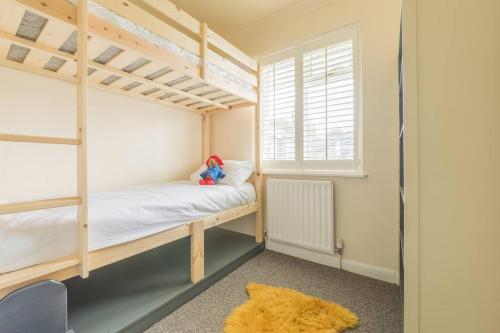 a bedroom with a bunk bed and a window at Tideway in Whitstable