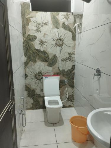 a bathroom with a toilet and a flower wallpaper at Hotel anand shree in Hoshangābād