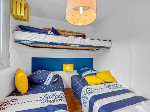 une chambre avec deux lits et un lit superposé dans l'établissement N102 Mobil Home Charmant à Sarlat, à Sarlat-la-Canéda