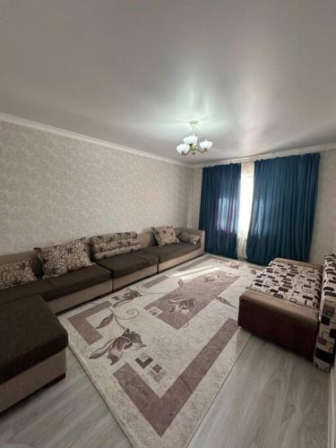 sala de estar con sofá y alfombra en Элитная 2-х комнатная квартира, en Shymkent