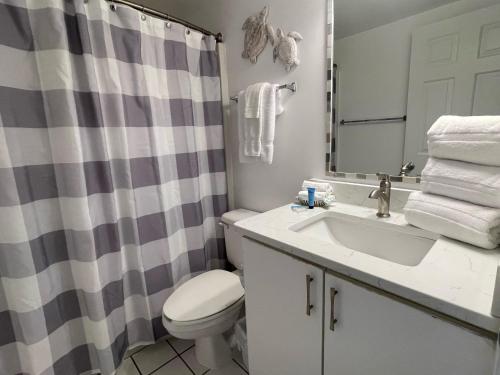 a bathroom with a sink and a toilet and a shower curtain at Tradewinds 908 in Orange Beach