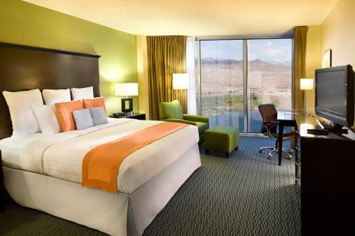 a hotel room with a bed and a desk and a television at Aquarius Casino Resort in Laughlin