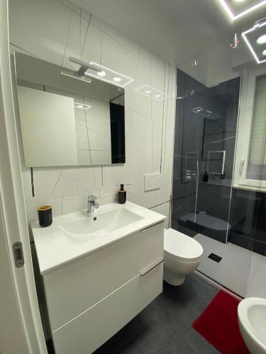La salle de bains blanche est pourvue d'un lavabo et de toilettes. dans l'établissement Affittacamere da Gigi, à Vintimille