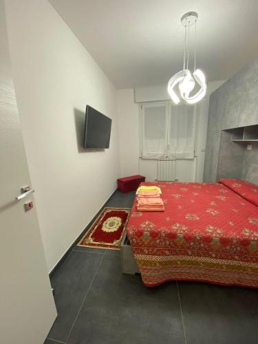 - une chambre avec un lit rouge et une télévision à écran plat dans l'établissement Affittacamere da Gigi, à Vintimille