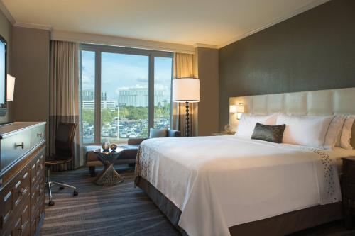 Habitación de hotel con cama grande y ventana grande. en Renaissance Tampa International Plaza Hotel en Tampa