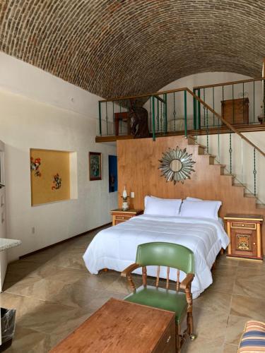 um quarto com uma cama grande e uma escada em LA ERMITA "Antigua casa de Cantinflas" em San Miguel de Allende