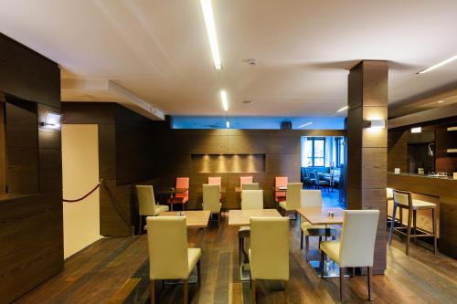 a dining room with white chairs and tables at Hotel Villa Delle Rose - Malpensa in Oleggio