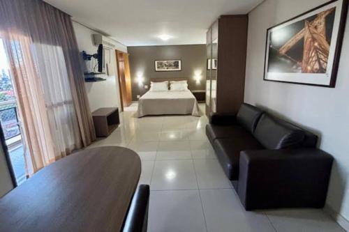 une chambre d'hôtel avec un lit et un canapé dans l'établissement Flat Apart Bristol Hotel Goiânia - Crystal Place, à Goiânia
