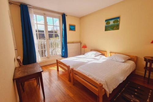 a bedroom with a bed and a large window at Bouchardine - Centre - Parking gratuit - Hospices in Beaune