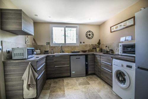 Il comprend une cuisine équipée d'un lave-linge, d'un évier et d'un lave-vaisselle. dans l'établissement Le charme de Landra, à Pernes-les-Fontaines