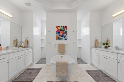 a white bathroom with a tub and two sinks at BIG WATER VIEW!, Heated Saltwater Pool and Spa - Villa Manatees Crossing - Roelens in Matlacha