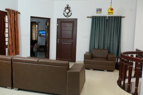 a living room with a couch and a chair at Marari Sailor Homestay in Shertallai
