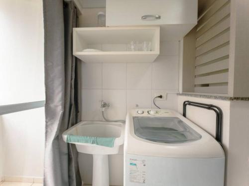 - un lave-linge dans la salle de bains pourvue d'un lavabo dans l'établissement Apartamento Wifi Smart - CID517A, à Maringá