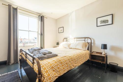 a bedroom with a bed and a window at Fig Tree Cottage in Whitstable