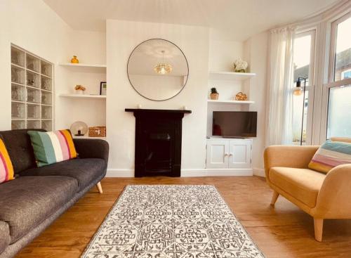 a living room with a couch and a mirror at Seal Cottage in Whitstable