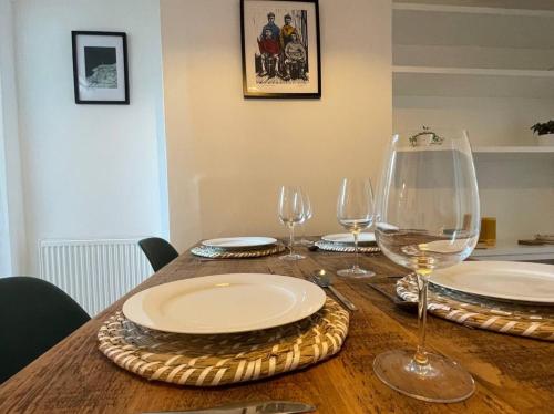 uma mesa de madeira com pratos e copos de vinho em Seal Cottage em Whitstable