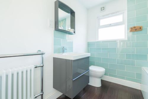 ein Bad mit einem Waschbecken und einem WC in der Unterkunft Shell Cottage in Whitstable